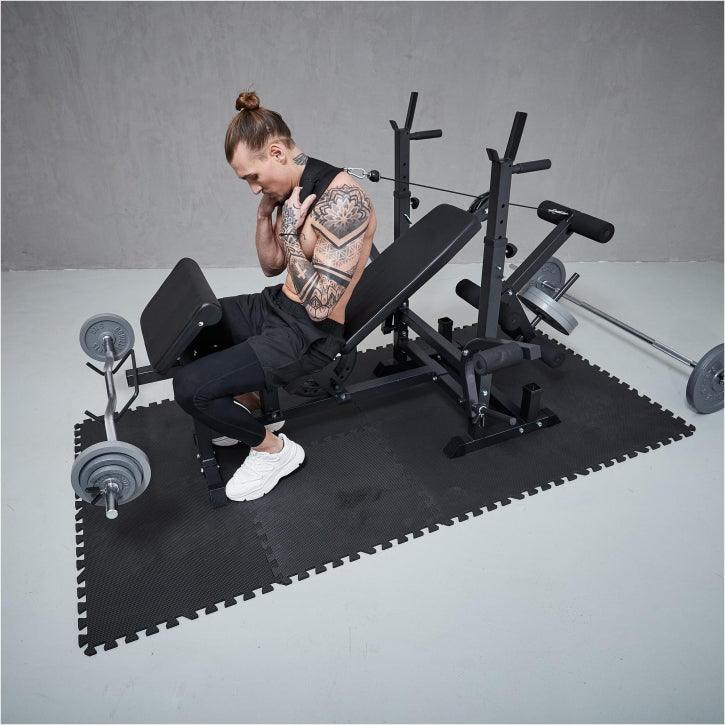 Uomo che si allena con panca multifunzione Gorilla Sports in palestra, attrezzi fitness in vista