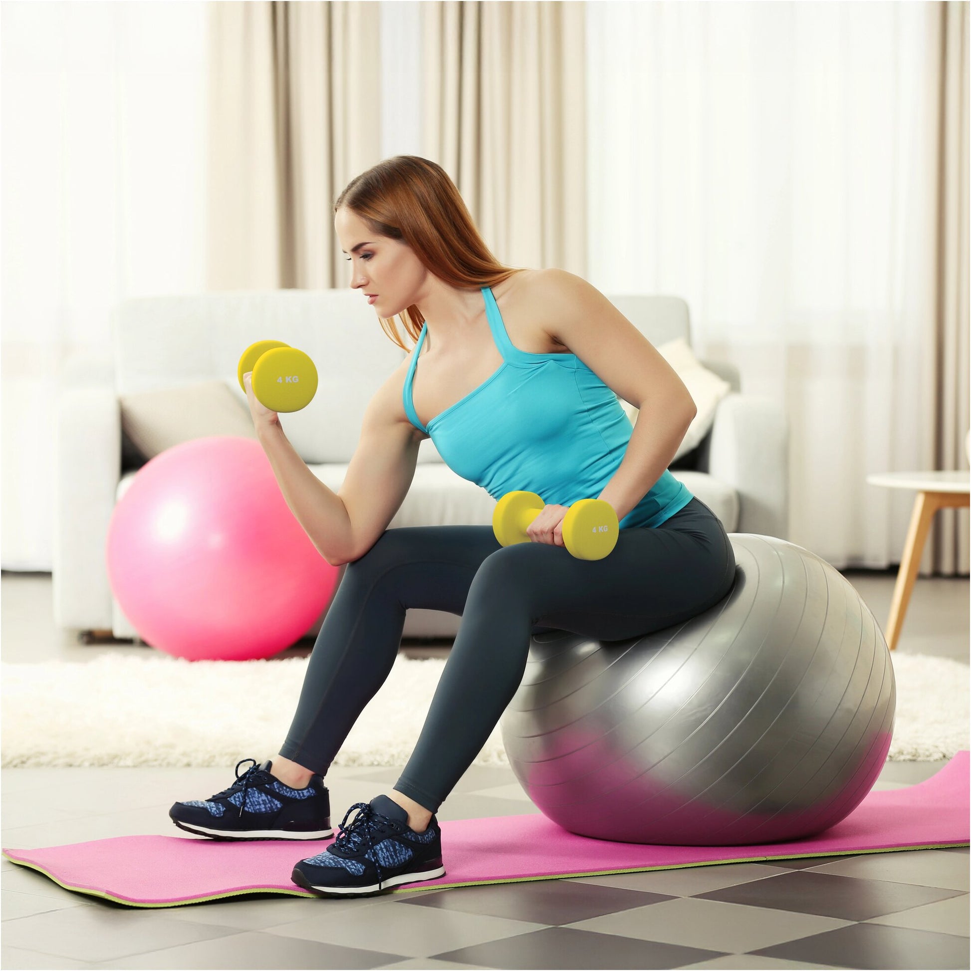 Donna fa allenamento fitness con manubri gialli su fitball, tappetino e palla rosa Gorilla Sports
