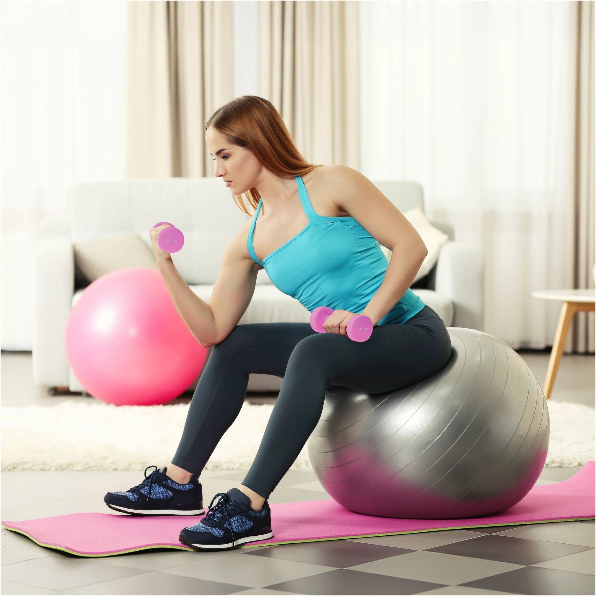 Donna che si allena con manubri rosa e fitball su tappetino, fitness Gorilla Sports