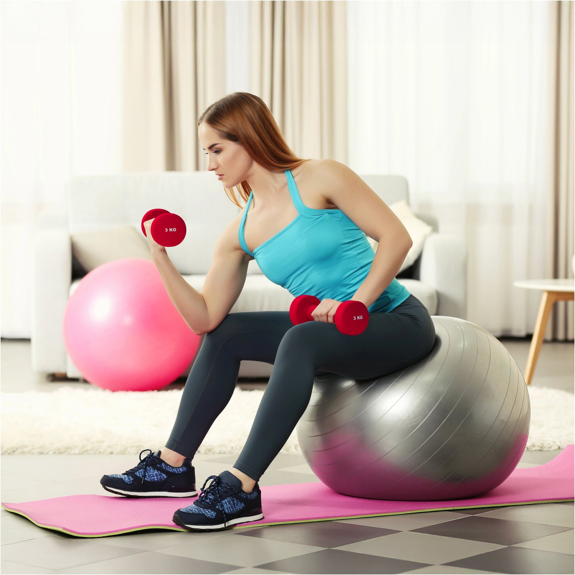 Donna che fa esercizi con manubri da 3 kg seduta su fitball, attrezzi fitness Gorilla Sports.