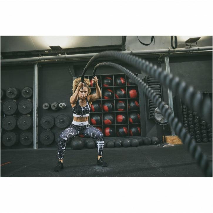 Donna fa allenamento fitness con battle rope in palestra, Gorilla Sports Bodybuilding