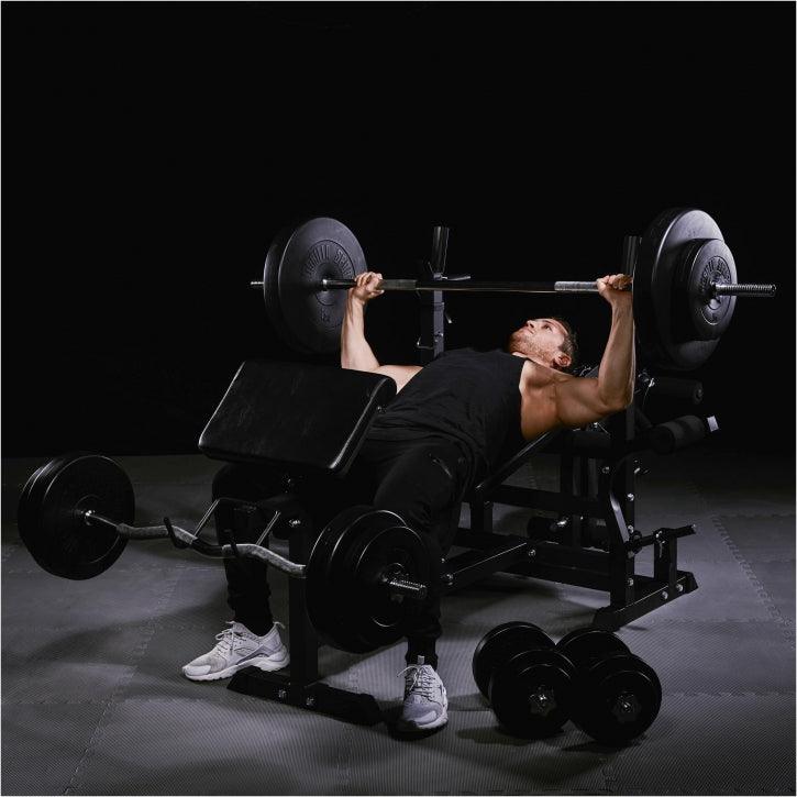 Uomo che esegue panca piana con bilanciere in palestra Gorilla Sports, attrezzatura fitness